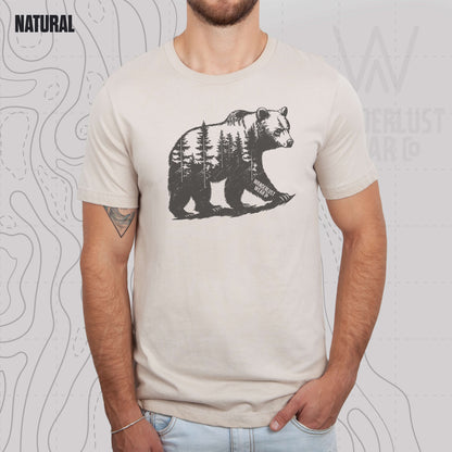 Model wearing Roam Wild Bear graphic tee in Natural, featuring hand-drawn bear silhouette with pine trees and Wanderlust Wear Co. branding