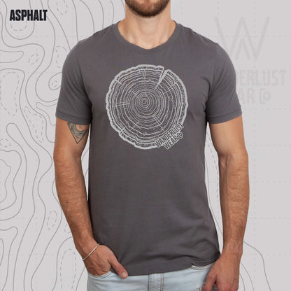 Model wearing Tree Rings Heritage graphic tee in Asphalt, featuring hand-drawn tree trunk cross-section design by Wanderlust Wear Co.