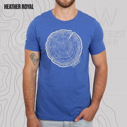 Model wearing Tree Rings Heritage graphic tee in Heather Royal, featuring hand-drawn tree trunk cross-section design by Wanderlust Wear Co.