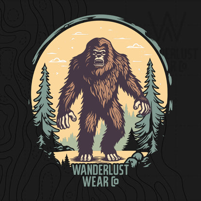 Close-up of Wilderness Watcher graphic tee design featuring a stylized Bigfoot in a misty pine forest with vintage colors and Wanderlust Wear Co. branding